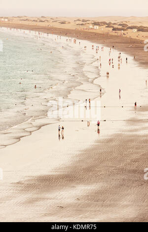 Hohes Bild der Menschen am Strand von Playa del Inglés, Gran Canaria. Dünen von Maspalomas im Hintergrund. Stockfoto