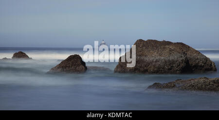 Eine verträumte lange Belichtung seascape Der felsformationen an der Küste von Oregon in Ecola State Park mit Tillamook Head Lighthouse im Hintergrund. Stockfoto