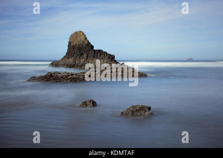 Eine verträumte lange Belichtung seascape Der felsformationen an der Küste von Oregon in Ecola State Park mit Tillamook Head Lighthouse im Hintergrund. Stockfoto