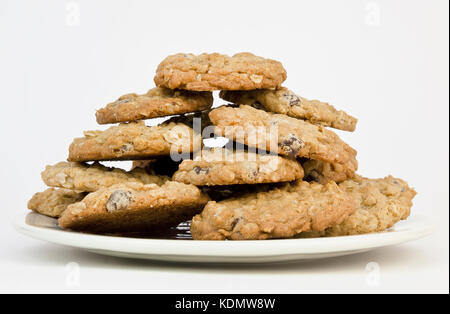 Vorderansicht eines Platte angehäufte Höhe mit hausgemachten Oatmeal raisin Chocolate Chip Kekse Cookies auf einem weißen Hintergrund. Stockfoto