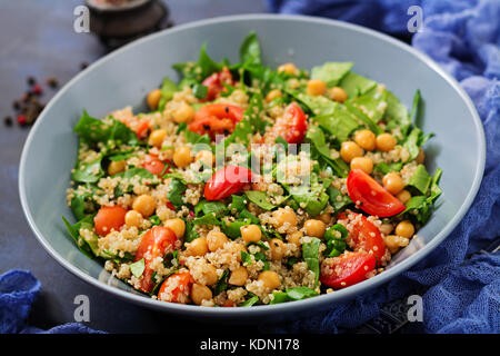 Diätetisches Menü. Gesunde vegane Salat von frischem Gemüse - Tomaten, Kichererbsen, Spinat und Quinoa in eine Schüssel geben. Stockfoto