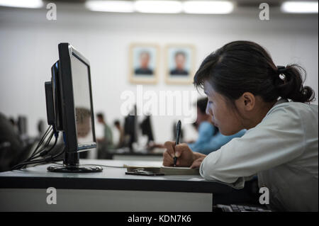 Des Nord coréens étudient à la grande maison des études du puple de Pjöngjang devant le Portraits des Leaders à Pjöngjang, Oktober 2012. Nordkorea Stockfoto