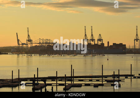 Southampton Docks container Hafen bei Sonnenuntergang mit einem großen Containerschiffen und Krane gegen die bunte Himmel. Stockfoto