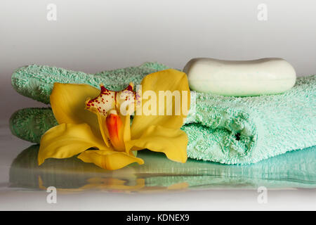 Türkis Handtuch mit Gelben Orchideen und Seife auf den weißen Hintergrund - Spa & Wellness Stockfoto