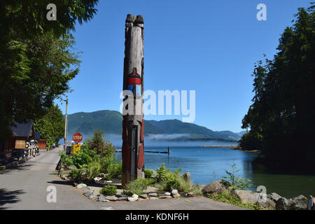 Totem Pole steigt über den Hafen mist-Port Renfrew, Vancouver Island, BC, Kanada Stockfoto