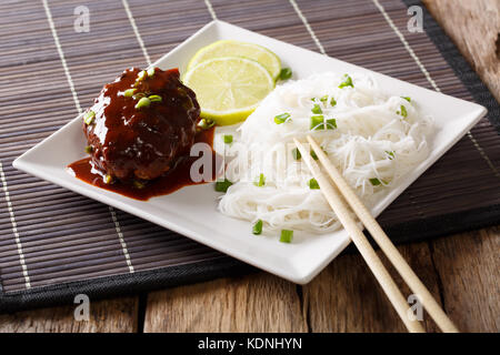 Japanisches Essen: hamburg Steak oder hambagu mit einer würzigen Soße und Reis Nudeln close-up auf einem Teller auf den Tisch. Horizontale Stockfoto