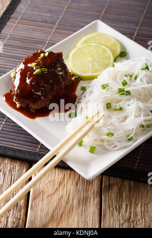 Japanische Küche: hambagu Steak mit Reis Suppennudeln und Kalk closeup auf einem Teller auf dem Tisch. Vertikale Stockfoto