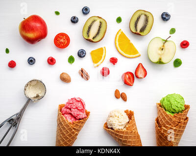 Kegel und bunten verschiedene Früchte Himbeere, Heidelbeere, Erdbeere, Orange Slice, Kiwi, Apfel, Tomate und Pfefferminze halbieren lässt Setup auf weißen Hinterg Stockfoto