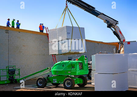 Mobiler Kran, der Polystyrol-Isolierplatten auf das Dach einer Mall-Baustelle in Port Charlotte FL hebt Stockfoto