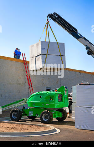 Mobiler Kran, der Polystyrol-Isolierplatten auf das Dach einer Mall-Baustelle in Port Charlotte FL hebt Stockfoto