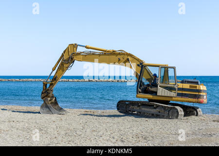 Bagger arbeiten am Strand den Sand vor der Sommersaison glatt zu Beginn Stockfoto