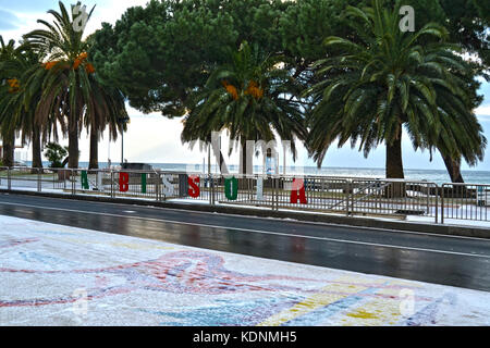 Gefrorene Straße neben dem Meer, unter Palmen, mit Blick auf den verschneiten Strand, in Italien Stockfoto