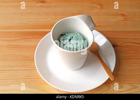 Eine Tasse mint Chocolate Chip Eis auf braune Holztisch serviert. Stockfoto