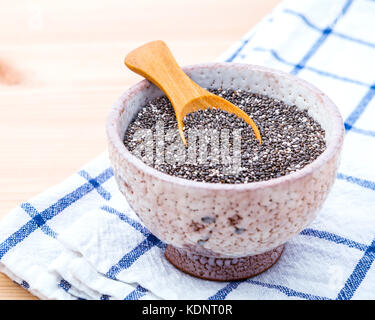 Nahrhafte Chia Samen in Keramik Schüssel auf Holztisch für Ernährung Lebensmittel Zutaten. nahrhafte Lebensmittel und Super Foods Auswahl mit geringer Tiefe von fi Stockfoto