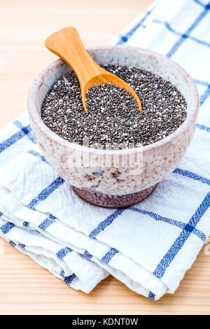 Nahrhafte Chia Samen in Keramik Schüssel auf Holztisch für Ernährung Lebensmittel Zutaten. nahrhafte Lebensmittel und Super Foods Auswahl mit geringer Tiefe von fi Stockfoto