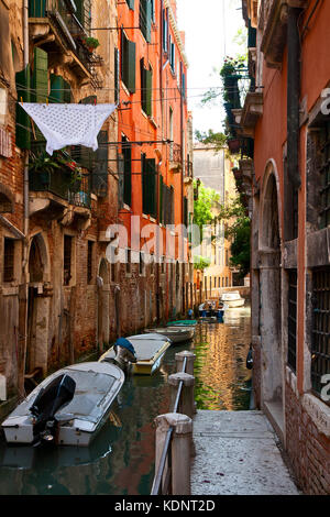 Boote in einem schmalen Kanal von Venedig. Stockfoto