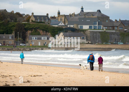 Wanderer geniessen Herbst Sonne auf den Sandstrand an der malerischen Badeort Lossiemouth, Schottland Stockfoto