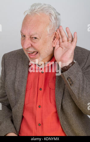 Schlecht hören Senior die Hand an seinem Ohr - auf hellen Hintergrund Stockfoto