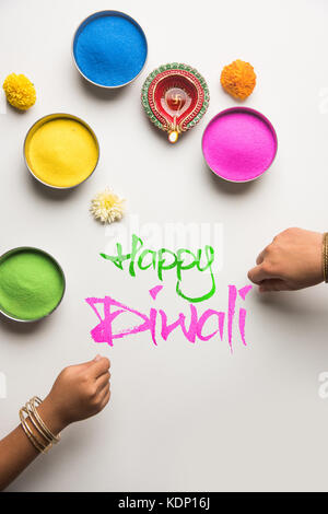 Foto von Happy diwali Grußkarte mit Klicken auf Elemente von Diwali Festival wie bunte rangoli in Schalen, diwali Ton Lampe oder Diya und Mädchen Stockfoto