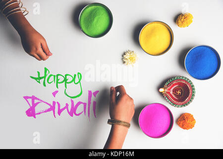 Foto von Happy diwali Grußkarte mit Klicken auf Elemente von Diwali Festival wie bunte rangoli in Schalen, diwali Ton Lampe oder Diya und Mädchen Stockfoto