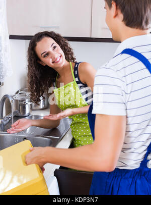Junge weibliche Kunden zufrieden professionelle Klempner für die Arbeit danken. Stockfoto