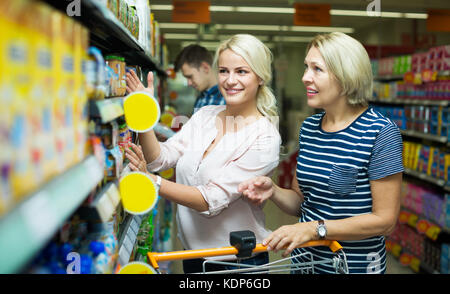 Positive weibliche Kunden den Kauf von Babynahrung in Gläsern im Supermarkt Stockfoto