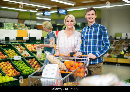 Positive lächelnde Kunden Auswahl frischer frusits im lokalen Supermarkt Stockfoto