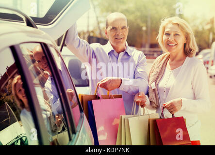 Lächelnd reifes Paar Einkäufe mit einem Aufenthalt in der Nähe von Booten geöffnet Stockfoto