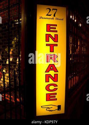 1997, Nacht- und die Nahaufnahme zeigt die hellen Farben Rot und Gelb neon 'Eingang'-Schild bei 27 Denmark Street, Bloomsbury, London, WC2H, England, für die berühmten Gitarre und Musik Shop, "Hanks'. Stockfoto