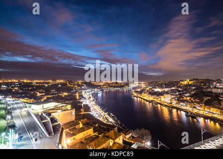 Abendhimmel über dem Douro-Fluss und den Städten Porto (rechts) und Vila Nova de Gaia, Portugal. Blick auf die Seilbahn Caia Stockfoto