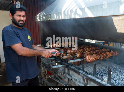 Mitarbeiter kochen Schwein und Huhn auf einem Grill auf dem Letzten Schloss Restaurant, auf der Halbinsel Akamas, Peyia Bezirk, Paphos, Zypern. Stockfoto