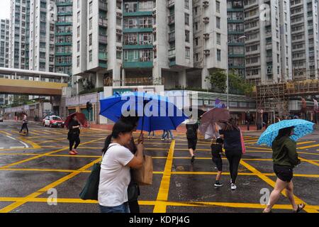 Hongkong, China. Oktober 2017. Menschen laufen im Regen in Hongkong, Südchina, 15. Oktober 2017. Chinas nationale Wetterbeobachtungsstelle setzte am Sonntag eine orange Warnung für den Taifun Khanun fort, der sich der Südküste des Landes nähert und starke Stürme und Sturme mit sich bringt. Quelle: Wang Shen/Xinhua/Alamy Live News Stockfoto