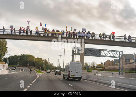 Runcorn. Vereinigtes Königreich. 15. Oktober. 2017. Demonstranten auf einer Brücke über die Zufahrtsstraße für die neue Mersey Gateway Bridge über den Fluss Mersey auf dem ersten Wochenende für den Verkehr. Die Brücke eröffnet um 1 Sekunde nach Mitternacht auf Oktober die 14. und es ist zu erwarten, mit 1,75 Mrd. £ kostet. Es gibt lokale Opposition auf die £ 2,00 Maut für Pkw für jede Kreuzung, die Probleme für viele, die die Brücke regelmäßig wie die alten gebührenfreien Brücke zu Nutzen verursachen könnte ofr Reparaturen geschlossen wurde. Quelle: John Davidson Fotos/Alamy Leben Nachrichten Runcorn. Vereinigtes Königreich. 15. Oktober. 2017. Quelle: John Davidson Ph Stockfoto