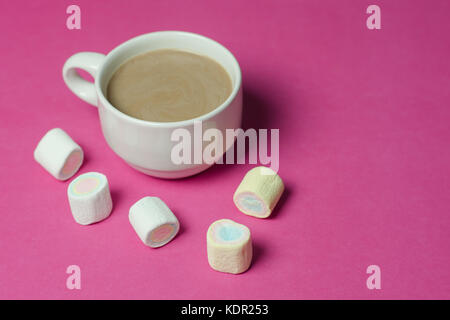 Heiße Schokolade mit Marshmallows in einem keramischen Cup auf rosa Papier Hintergrund Stockfoto