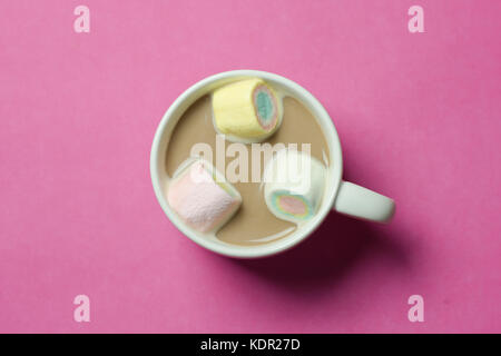 Heiße Schokolade mit Marshmallows in einem keramischen Cup auf rosa Papier Hintergrund Stockfoto