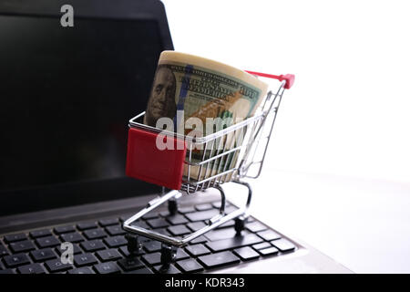 Warenkorb mit Dollar auf Laptop Tastatur Stockfoto