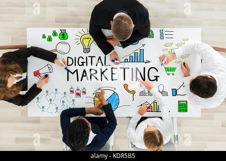 Hohe Betrachtungswinkel und Geschäftsleute als Zeichnung Digital Marketing Diagramm auf Schreibtisch mit bunten Marker Stockfoto