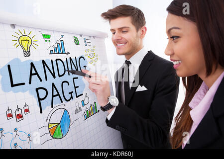 Zwei glückliche Geschäftsleute diskutieren landing page Konzept auf Flipchart in Office mit Markierung Stockfoto