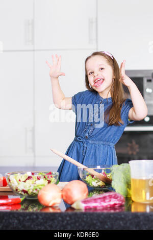 Kleine süße Mädchen schwelgt in Küche, Familienkonzept Stockfoto