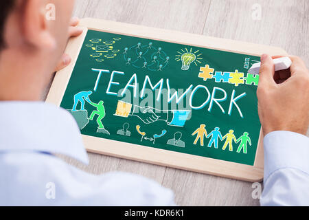 Hohe Betrachtungswinkel der Unternehmer Zeichnung Teamarbeit Konzept auf Schiefer an der hölzernen Schreibtisch Stockfoto