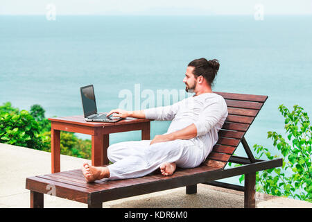 Unternehmer tragen weiße mit Laptop am Strand Stockfoto
