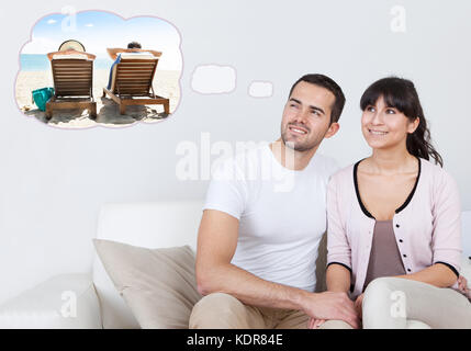 Junges Glückliches Paar Auf Dem Sofa Träumen Davon, Gemeinsam Urlaub Am Strand Zu Hause Zu Verbringen Stockfoto