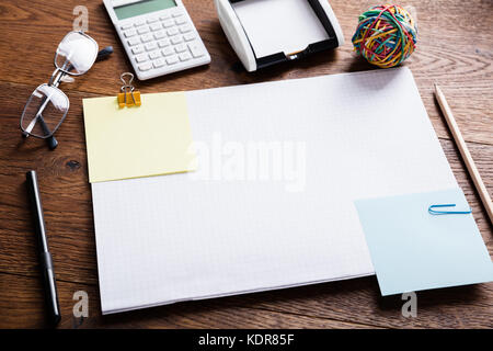 Hohe Betrachtungswinkel von bunten Papier Hinweis beigefügt, das auf Notebooks mit Büroklammern für die Erinnerung auf hölzernen Schreibtisch Stockfoto