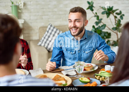 Junger Mann Sie das Abendessen mit Freunden Stockfoto