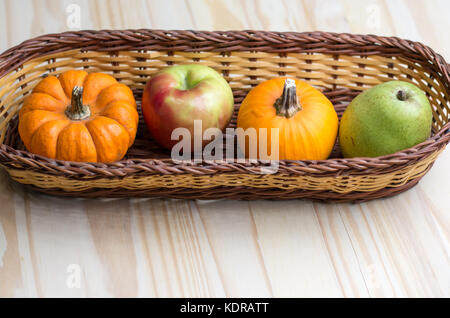 Herbst Ernte von Äpfeln, Birnen und Kürbisse in einem Weidenkorb. Stockfoto