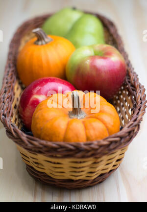 Herbst Ernte von Äpfeln, Birnen und Kürbisse in einem Weidenkorb. Stockfoto