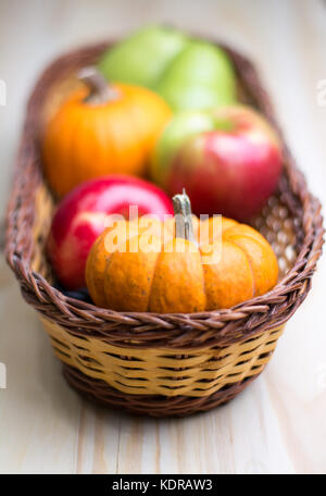 Herbst Ernte von Äpfeln, Birnen und Kürbisse in einem Weidenkorb. Stockfoto