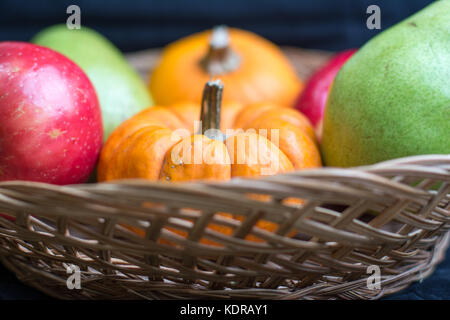 Herbst Ernte von Äpfeln, Birnen und Kürbisse in einem Weidenkorb. Stockfoto