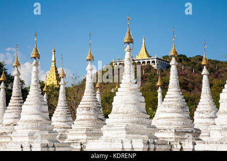 Die vielen weißen Stupas des Sandamuni-Pagode-Komplexes mit dem Mandalay-Hügel im Hintergrund, Mandalay, Burma Stockfoto