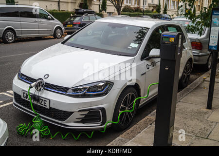 Ein Modell Volkswagen 2017 eGolf Elektroauto an eine Zipcar Electrobay Ladestation, St. John's Woods, London NW8, England Stockfoto